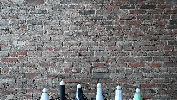 The barrel of several hair dryers facing upward with ping pong balls hovering over them.