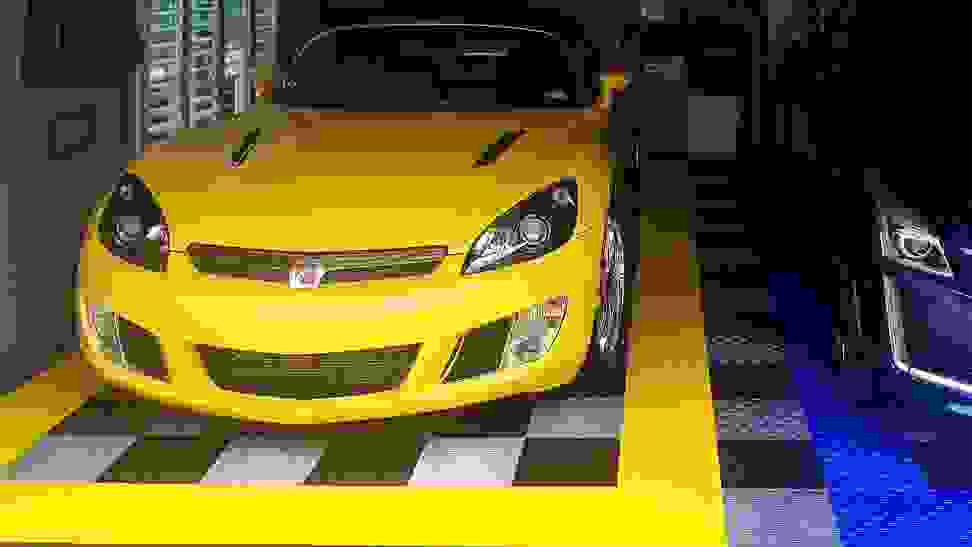 A car owner's garage flooring being used to store his cars and work on them comfortably.