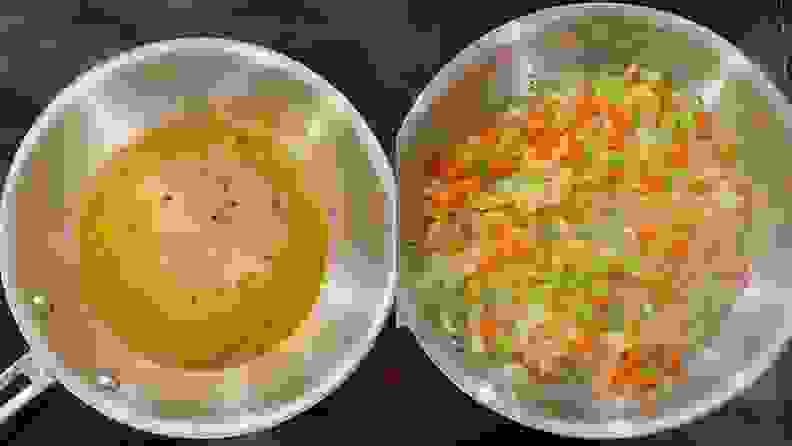 Diced vegetables and broth sitting inside of stainless steel sautée pan.