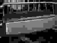 A close-up of the front of a Bosch dishwasher's top rack, which has the Bosch logo on it.