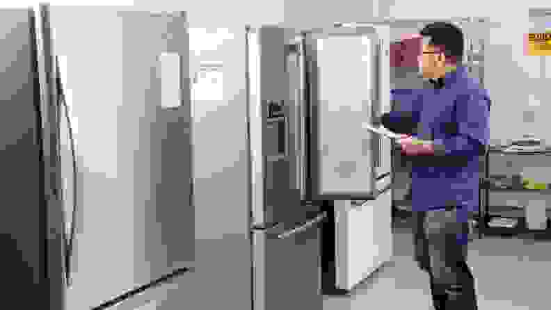 Our lab operations manager, Jonathan Chan, stands before a line-up of fridges in our testing lab.