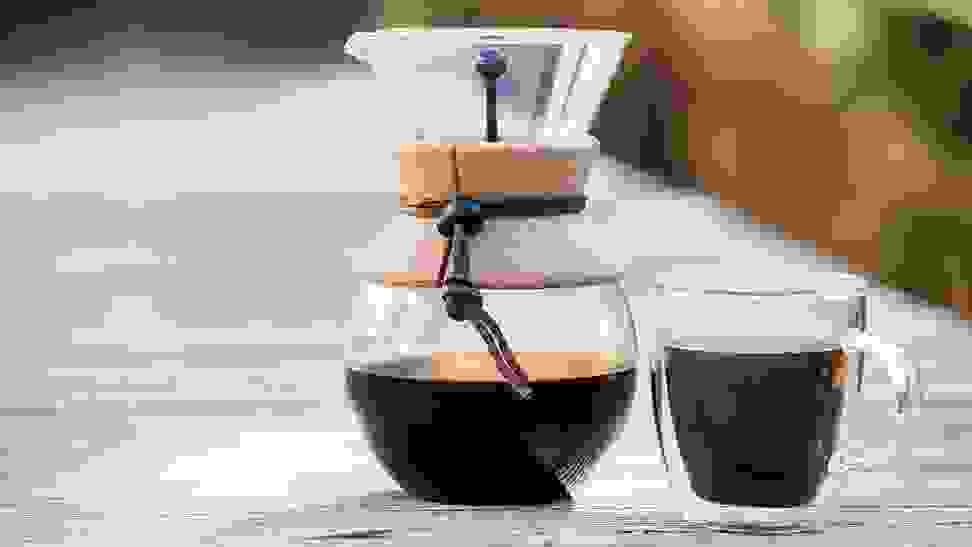Clear coffee mugs being used by two friends to drink espresso on the porch.
