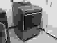 A gray Whirlpool dryer placed in a laundry room.