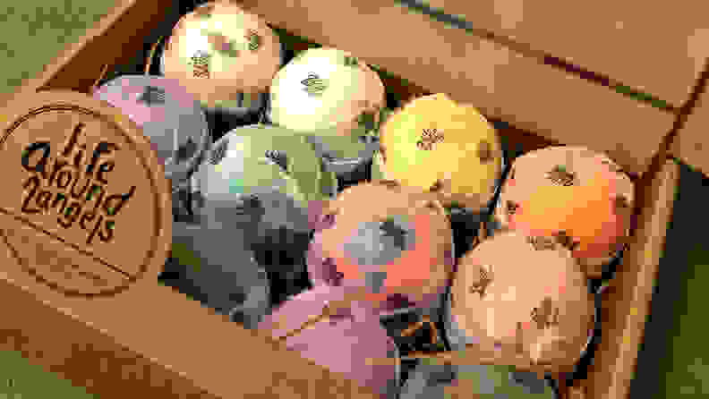 A box of spherical bath bombs, each a different color.