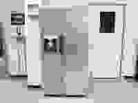 Stainless steel Midea MRS26D5AST Side-by-Side Refrigerator in front of white wall and white door.