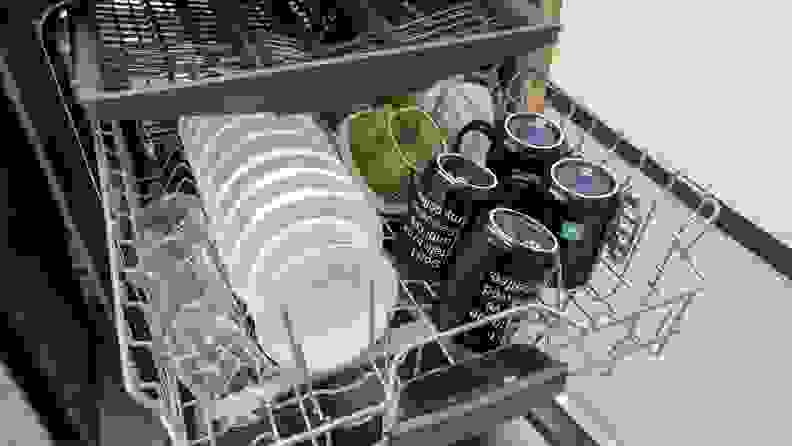 A close-up of the middle and third racks. The middle rack is full of small bowls, mugs, and cups, while the third rack is filled with neat rows of utensils.