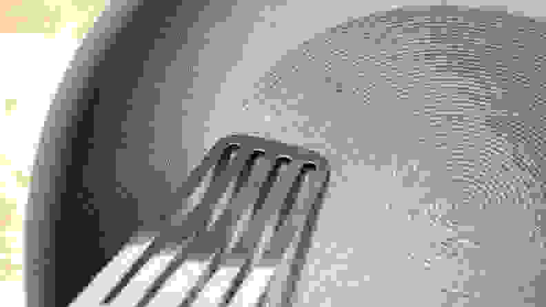 A metal thin spatula scraping the Circulon ScratchDefense Nonstick Frying Pan.