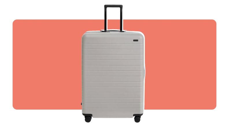A gray hard shell Away Large roller bag with handle extended.
