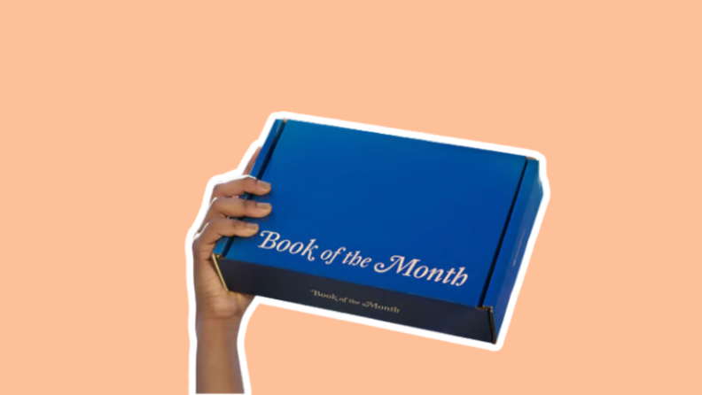 A hand holds a box from the Book of the Month club.