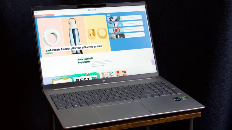 The laptop is on a dark desk against a black background.