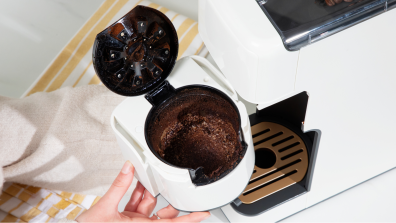 Close-up of a reusable coffee filter filled with used grounds.