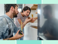 A man and woman stand next to a refrigerator. The man has a tape measurer and the woman is gesturing towards the fridge, which sticks out beyond the cabinetry.