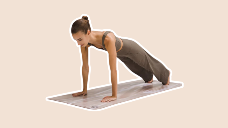 A person performs the plank yoga pose on a lululemon The Mat 5mm, the best yoga mat we've tested.